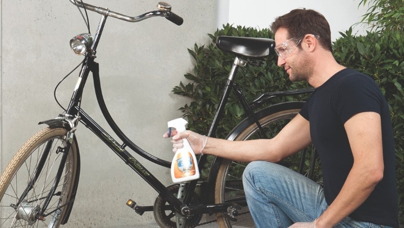 Ein Mann entfernt rostige Stellen an seinem Fahrrad mit Rostentferner von Molto