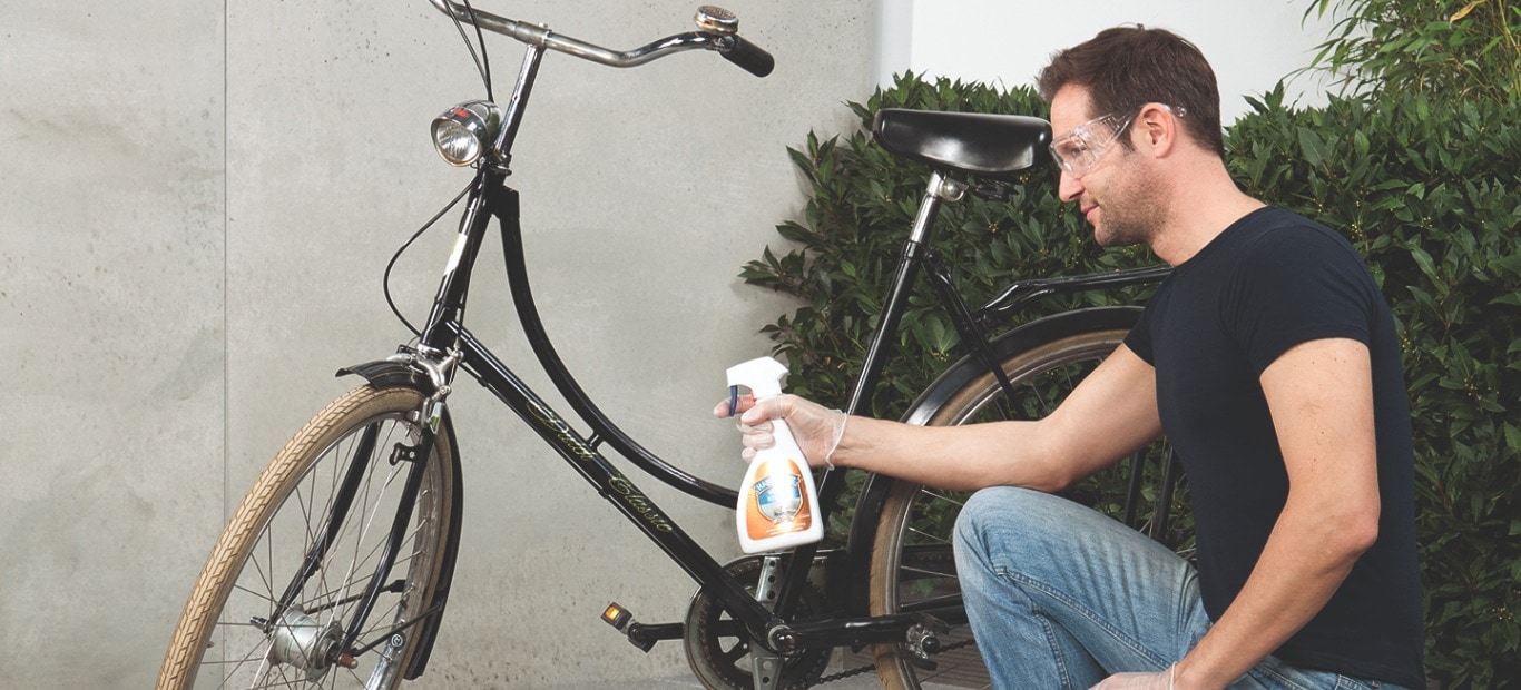 Ein Mann entfernt rostige Stellen an seinem Fahrrad mit Rostentferner von Molto