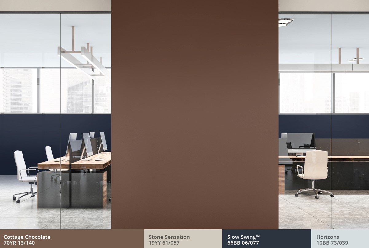 Workspace with rank of desks and brown dividing wall