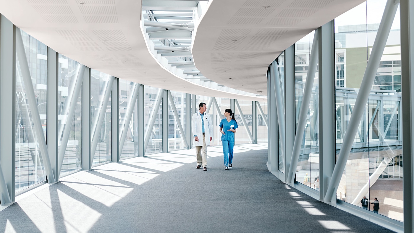 En bropassage med glas fra gulv til loft og et loft malet i en blød lyserød farve