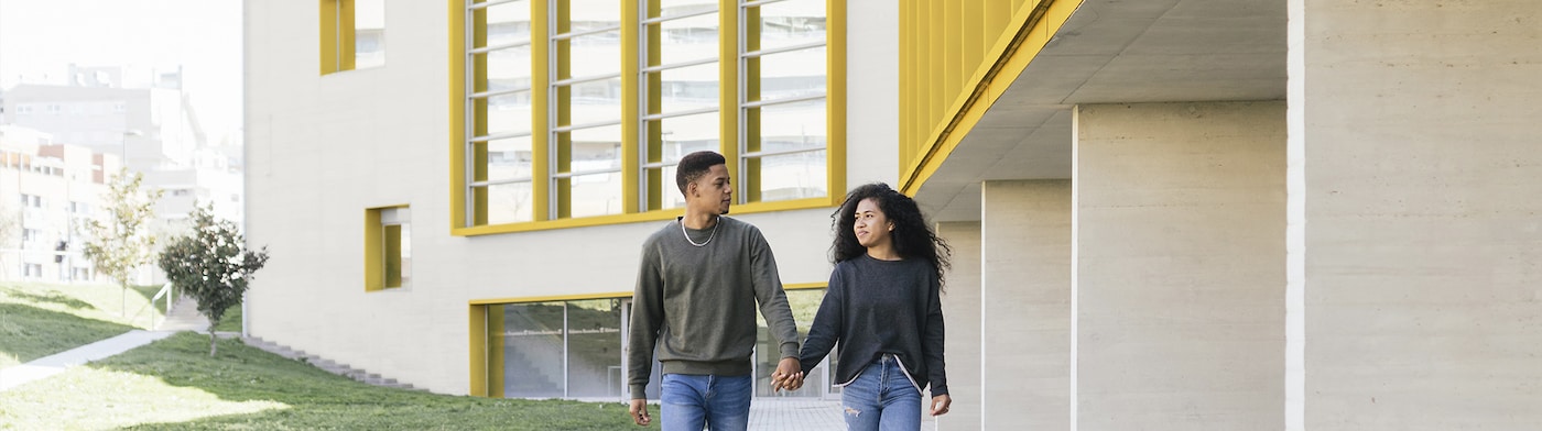 To patienter der går udenfor et gulmalet hospital