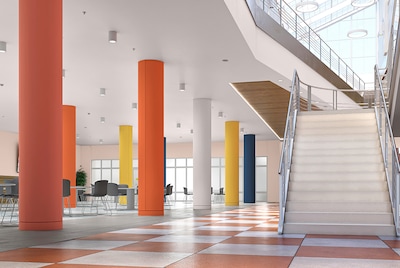 A school hallway with pilars painted in bright colours and  a white staircase