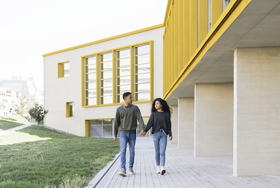 Two patients walking outside a hospital that painted bright yellow