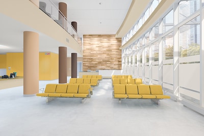 A modern healthcare building with yellow seats and yellow painted wall