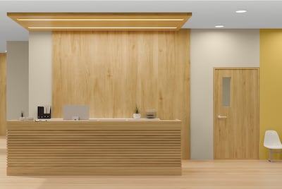 A modern wooden reception area with yellow statement walls behind