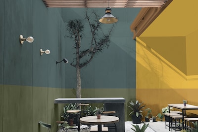 A restaurant patio area with green and blue walls on the left handside and yellow walls on the right 