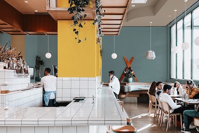 Restaurant with large yellow pillar and white-tiled bar