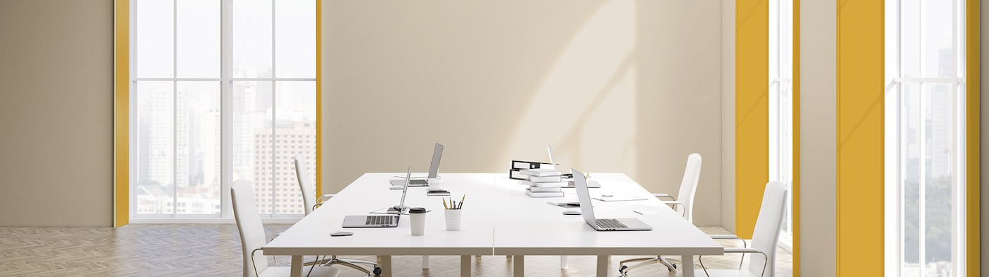 Kontorlokale med et stort bord og vinduer indrammet i gult