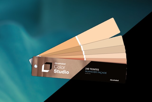 Nuancier AkzoNobel Color Studio en éventail présentant des tons chauds beiges et orangés avec marquage "240 teintes nuancier façade" sur fond turquoise.