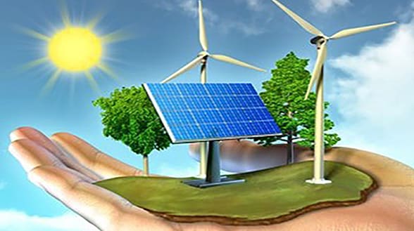 Een hand houdt een klein stukje groene aarde vast met zonnepanelen, windturbines en bomen, wat symbool staat voor duurzaamheid en hernieuwbare energie