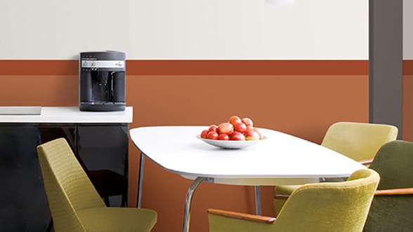 eettafel met fruitschaal en stoelen rondom met daarnaast een kastje met koffieapparaat