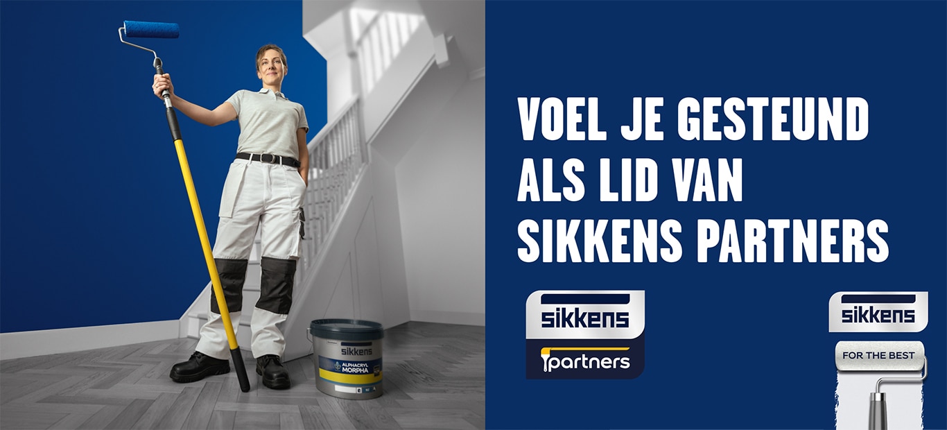 vrouwelijke schilder met een verfrol in de hand voor een donkerblauwe muur en een witte trap