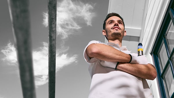 Maler posiert vor einem fertigen Holzhaus