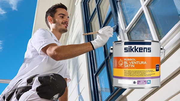 Maler streicht einen Fensterstock im Außenbereich