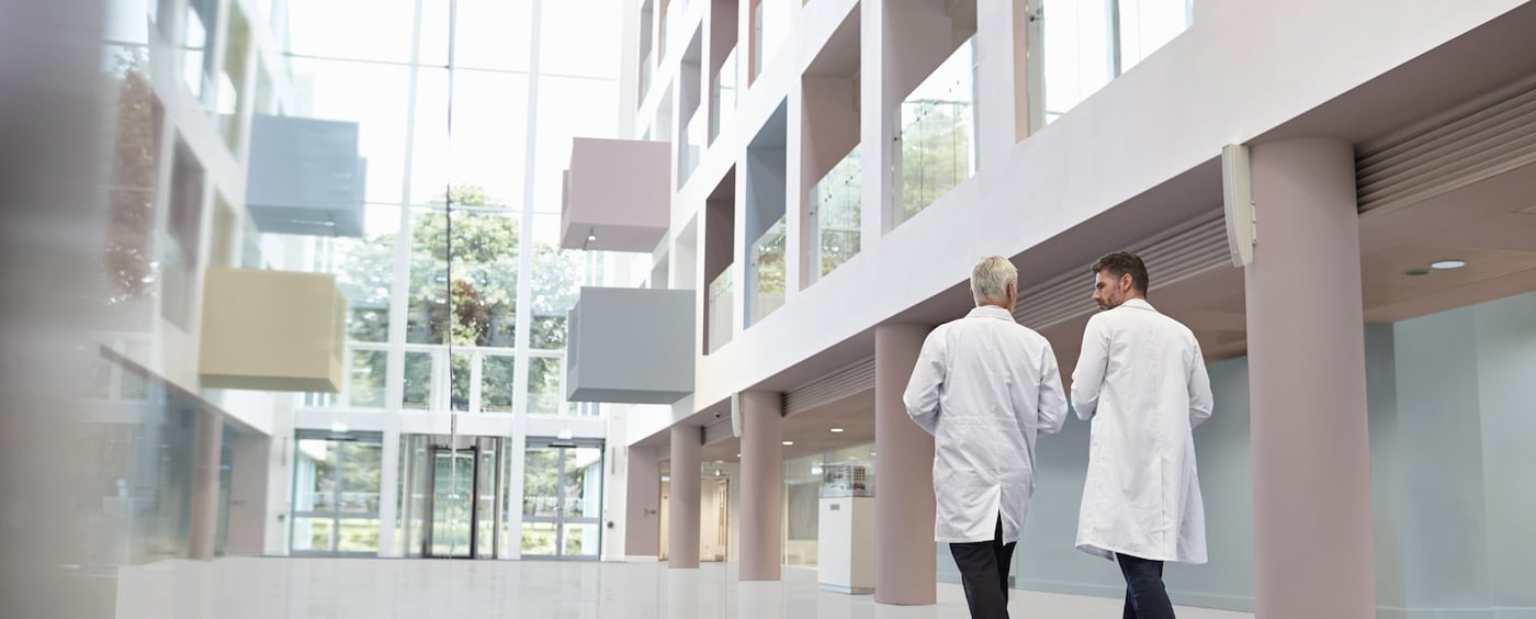 To læger går hen mod døren i et stort atrium