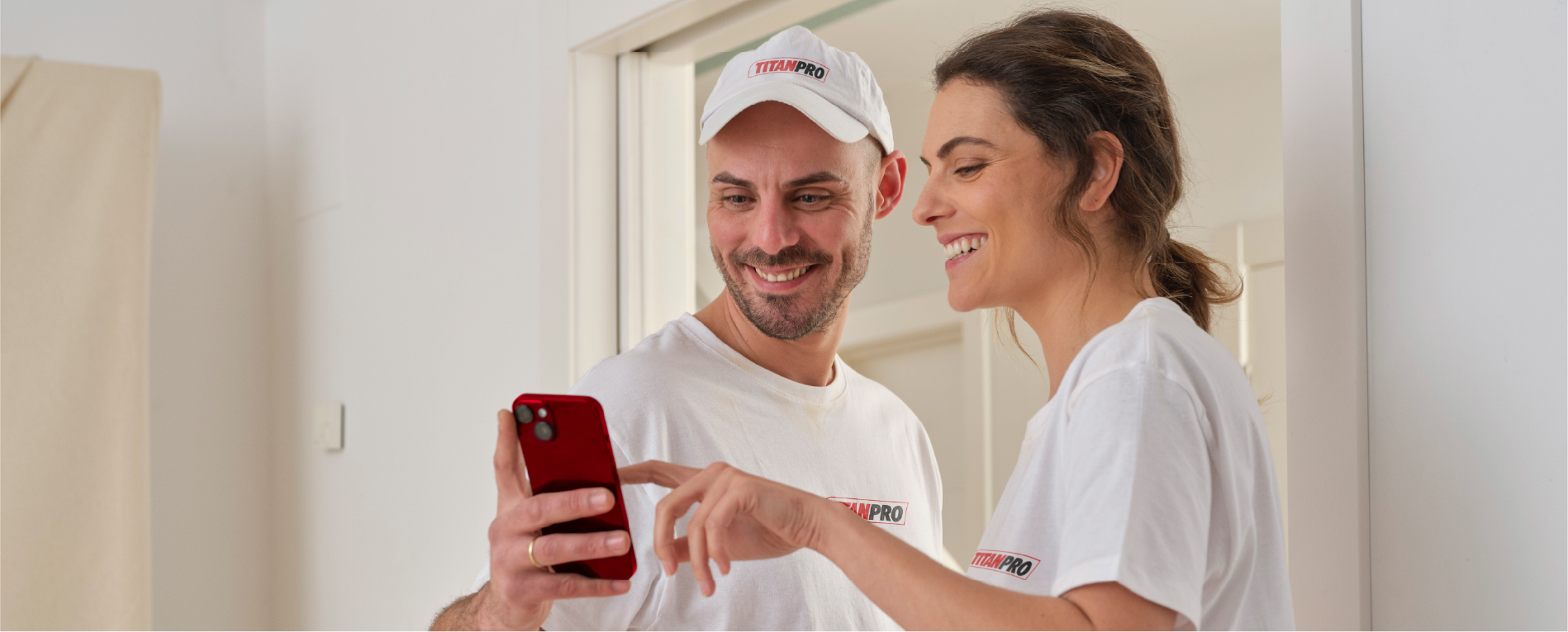 Pareja sonriente satisfecha con los resultados de pintura TitanPro en su hogar
