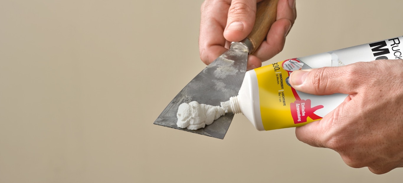 Schnelltrockende Spachtelmasse von Molto wird aus einer Tube auf einen Spachtel gedrückt