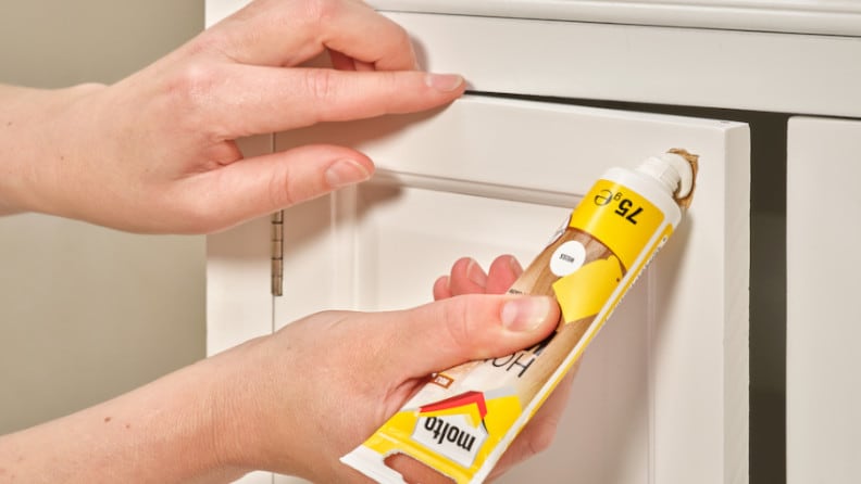Holz-Kitt von Molto wird in eine Schadstelle an einer Schranktür gefüllt