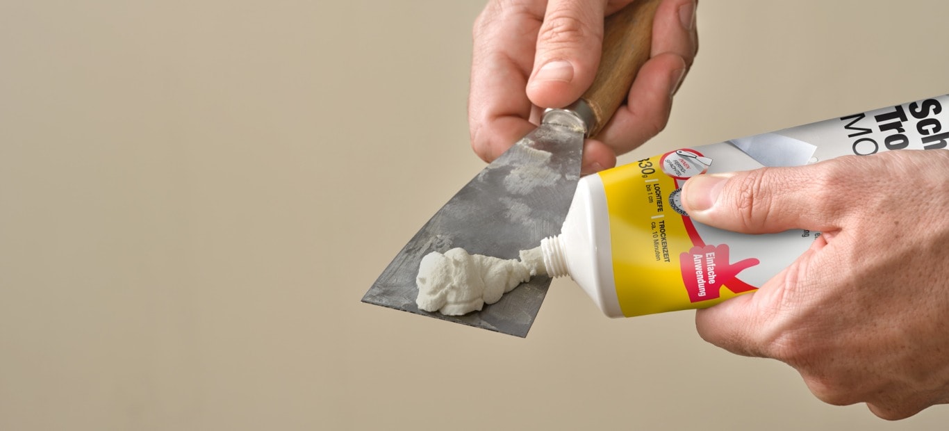 Schnelltrockende Spachtelmasse von Molto wird aus einer Tube auf einen Spachtel gedrückt