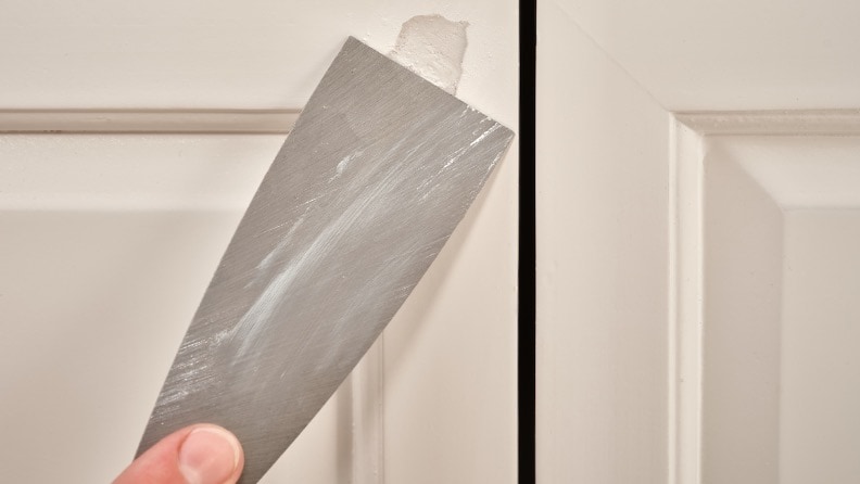 Holzspachtelmasse wird mit einem Spachtel geglättet