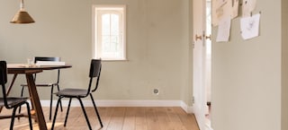 Eine Frau füllt eine herausgebrochene Fuge zwischen Fliesen im Bad mit Fliesen Fix von Molto direkt aus der Tube.