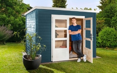 Ein in Nachtblau gestrichenes Gartenhaus