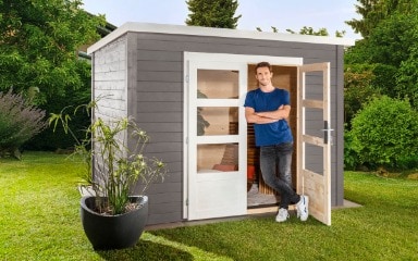 Ein in Steingrau gestrichenes Gartenhaus