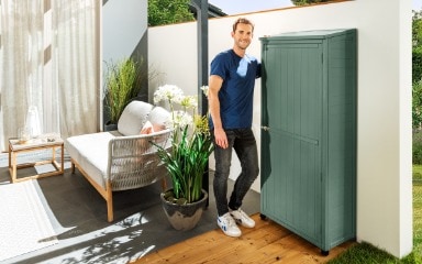 Ein in Royalgruen gestrichener Gartenschrank
