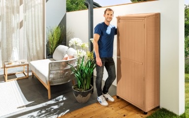 Ein in Sandgelb gestrichener Gartenschrank