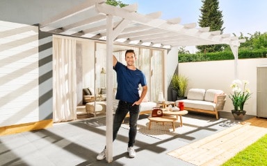 Eine in Kieselweiss gestrichene Pergola