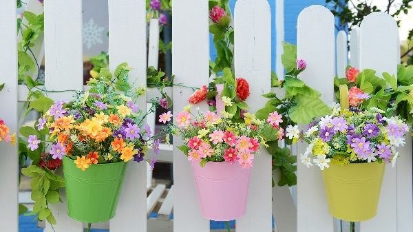 weißer Gartenzaun aus Holz mit Blumentöpfen