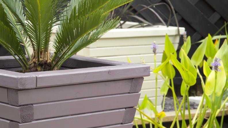 Mit anthrazitgrauer Wetterschutzfarbe von Consolan gestrichener Pflanzkübel